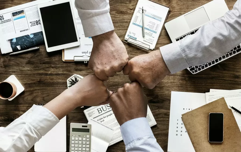 4 mains d'employés qui se checkent