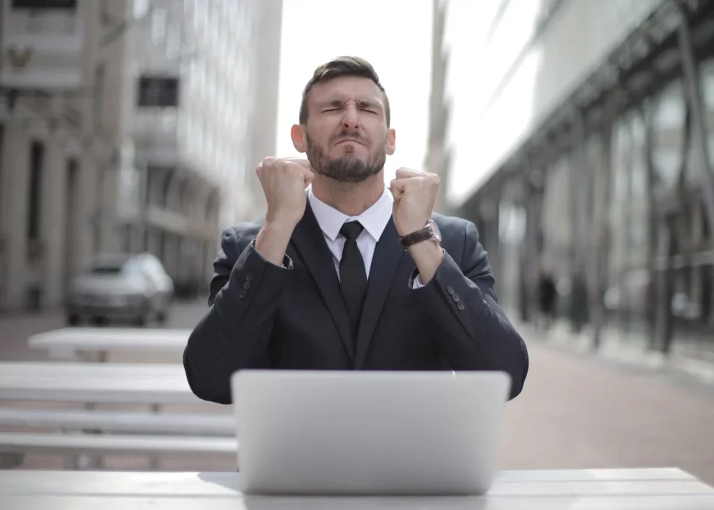 un entrepreneur devant son pc qui savoure une victoire